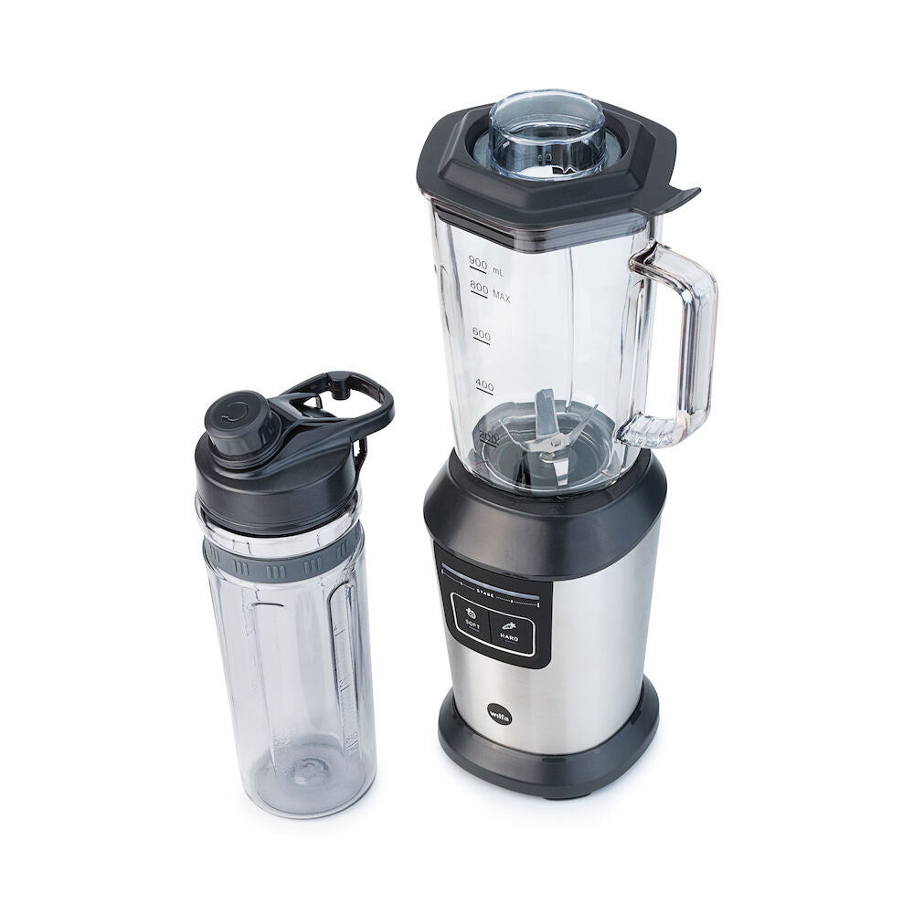 A stainless steel sports blender with a transparent pitcher filled with blueberries, spinach, and other fruits. Next to it is an ACTIVLIFE STEEL 2go bottle containing a dark purple smoothie topped with a secure lid. A small bunch of blueberries and a couple of mint leaves are placed nearby.