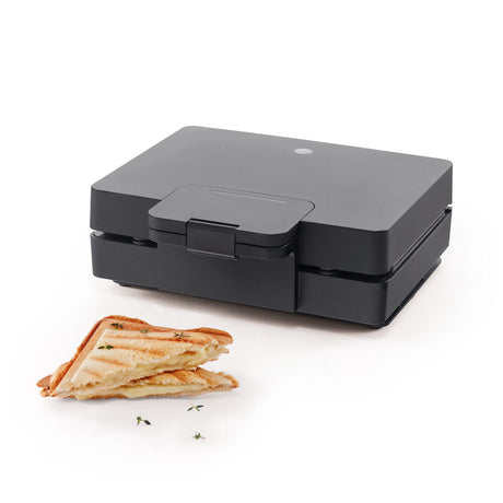 An EASY MELT open sandwich maker with two triangular cooking compartments, featuring ridged surfaces and large heating plates for grilling. The appliance is black, with a non-stick coating, a handle on the top, and a power cord at the back.